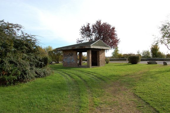 Schutzhütte aus Stein auf grüner Wiese
