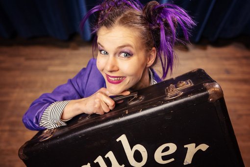 Zauberkünstlerin mit einem Koffer in der Hand