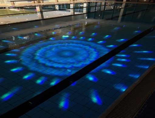 Schwimmbecken das im dunkeln beleuchtet ist