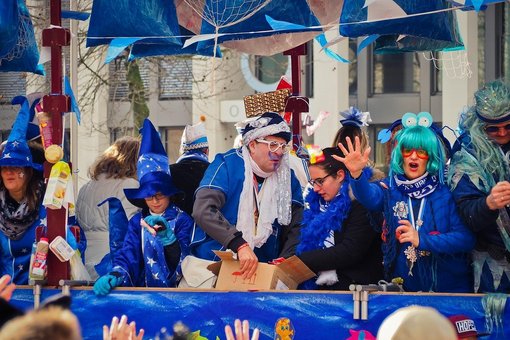 Blau verkleidete Personen auf einem Umzugswagen