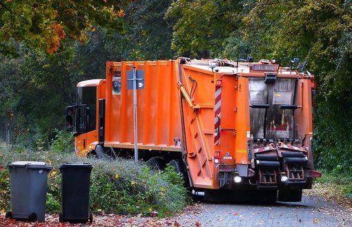 Orangenes Müllauto am Waldesrand