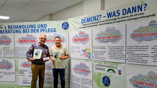 Bürgermeister Christian Jung und Andreas Sauder, Landesfachstelle Demenz Saarland, präsentieren die beiden Aufstellter der Ausstellung Demenz