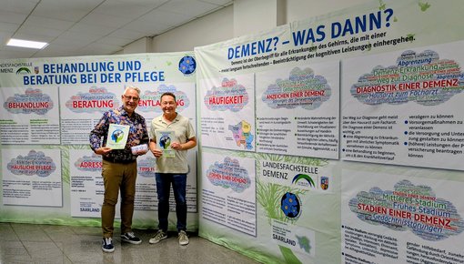 Bürgermeister Christian Jung und Andreas Sauder, Landesfachstelle Demenz Saarland, präsentieren die beiden Aufstellter der Ausstellung Demenz