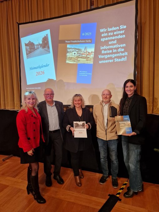 5 Personen der Stadt und der vhs des Regionalverbandes Saarbrücken stehen im Festsaal