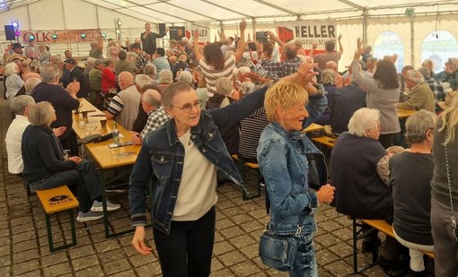 Zwei Frauen tanzen im einem Festzelt zur Musik des Sängers