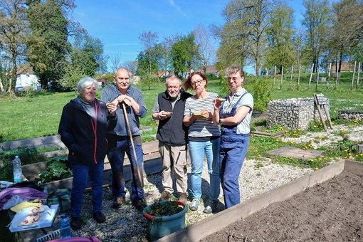 Mitglieder des Generationenbeirats stehen im Inselgarten mit Verpflegung in der Hand