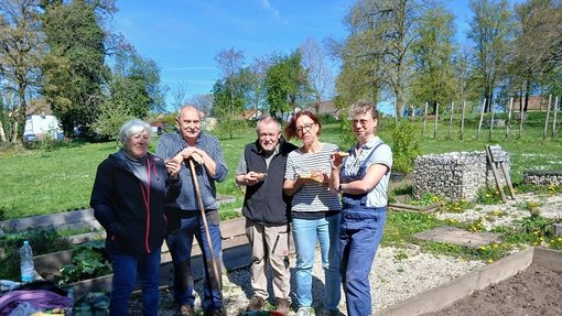 Mitglieder des Generationenbeirats stehen im Inselgarten mit Verpflegung in der Hand