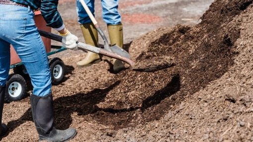 Mulcharbeiten Personen mit Schaufel arbeiten mit Mulch