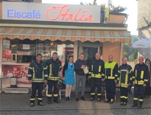 Bild mit Feuerwehrmännern und Frauen vor der Eisdiele