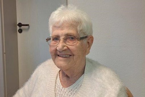 Frau mir grauen Haaren und weißem Pulli