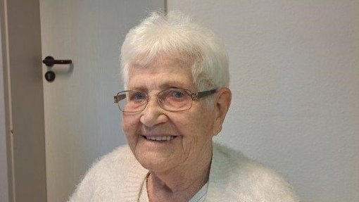 Frau mir grauen Haaren und weißem Pulli