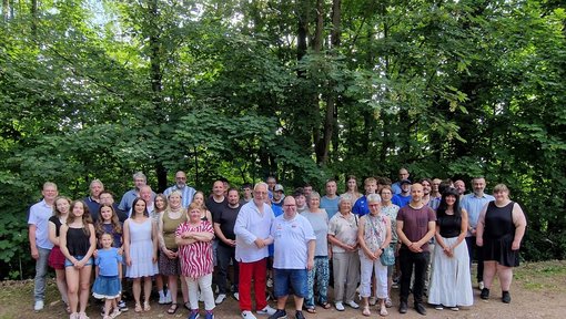 Alle Athleten und die Mitglieder der Verwaltung haben sich vor einem Waldstück aufgestellt
